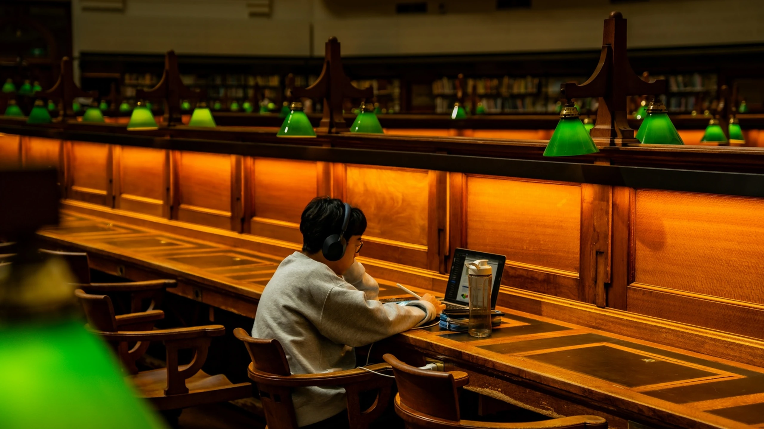 Student in een warme bibliotheekleeszaal als full-screen tussenbeeld.