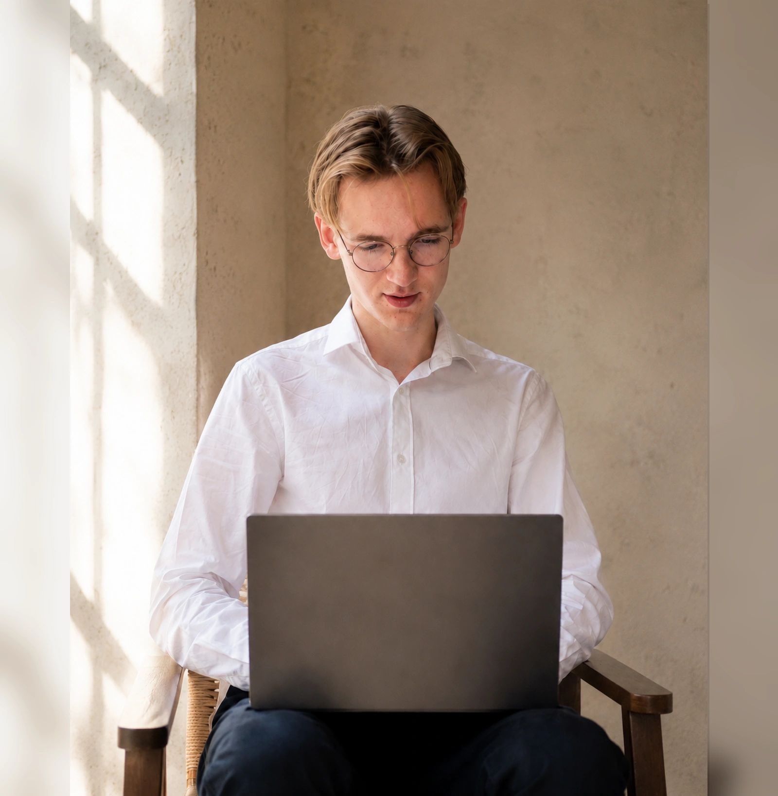 Middelbare scholier werkt rustig met laptop in zacht daglicht.